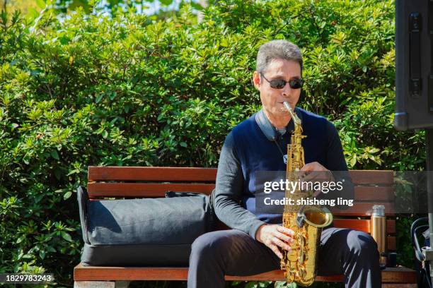 profitez d’une retraite anticipée.profitez d’un moment de détente en ville, profitez de la musique et de la famille heureux avec de bons amis - saxaphone portrait photos et images de collection