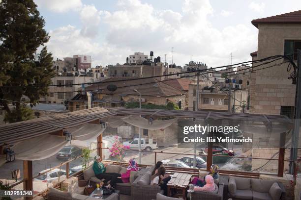 People dine outside at a restaurant on September 19, 2013 in Ramallah, West-Bank. The West Bank and Gaza Strip are inhabited by an estimated 3.33...