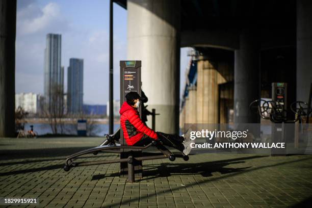 Person uses a public exercise facility under a bridge next to the Han River in Seoul on December 7, 2023.