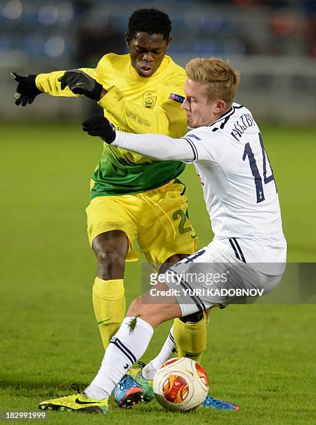 Anji's defender Ayodele Adeleye vies with Tottenham's midfielder Lewis Holtby during the UEFA Europa League Group K football match Anji Makhachkala...