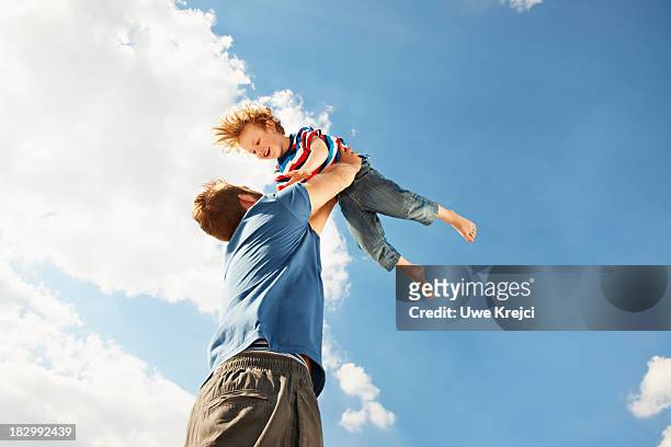 father and son playing - vista de ángulo bajo fotografías e imágenes de stock