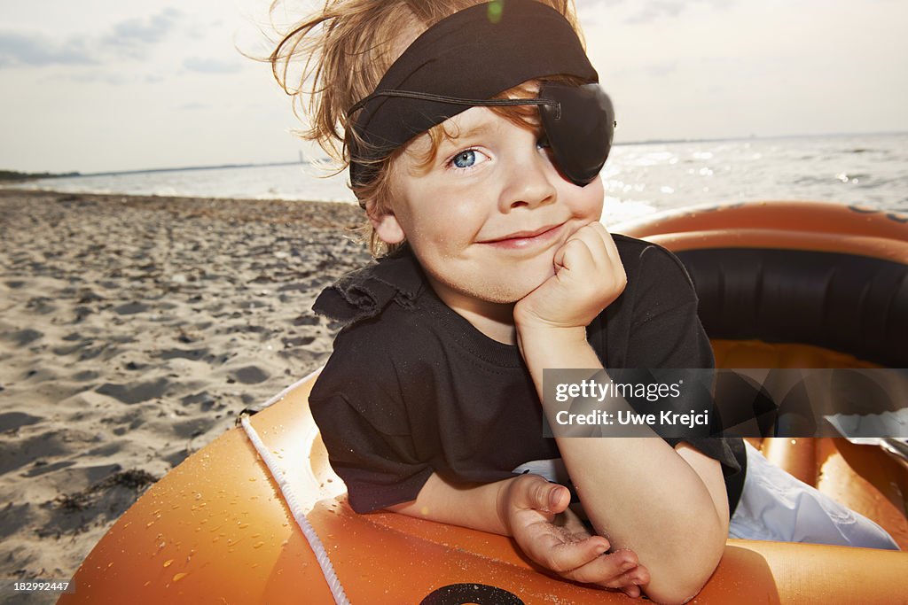 Boy (4 - 5 years) dressed as pirate on beach