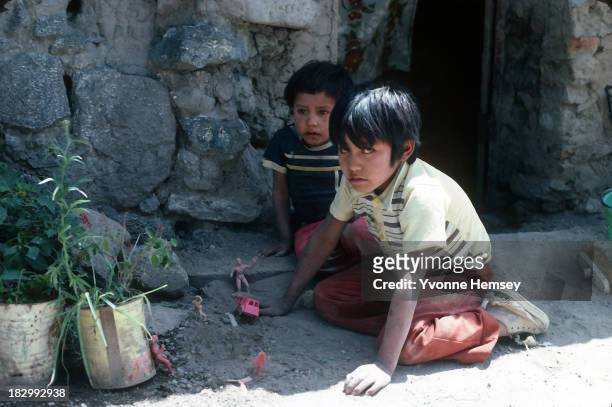 Two brothers, alone in their home, play outside their house September 4, 1982 in Santa Catarina, Mexico. Poverty is prevalent in Santa Catarina.