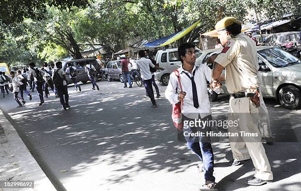 Policemen controlling students of Government Boys Senior School at Chittaranjan Park after their protest against the Principal over injury of class...