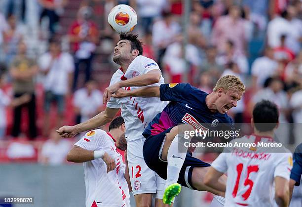 Vicente Iborra of Sevilla FC wins the header before Mike Hanke of SC Freiburg during the UEFA Europa League group H match between Sevilla FC and SC...