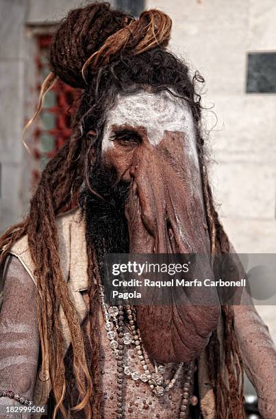 Portrait of sadhu, holy man for hinduists, suffering elephantiasis. Varanasi ghats, Benares, Uttar Pradesh, India