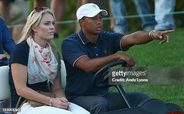 Skiier Lindsey Vonn waits with Tiger Woods during the Day One Four-Ball Matches at the Muirfield Village Golf Club on October 3, 2013 in Dublin, Ohio.