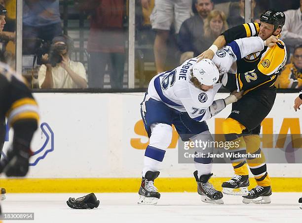 Shawn Thornton of the Boston Bruins and Pierre-Cedric Labrie of the Tampa Bay Lightning fight in the first period during the home opener game on...