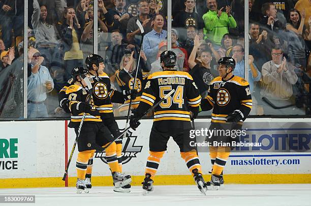 Milan Lucic of the Boston Bruins and his teammates celebrate his goal against the Tampa Bay Lightning at the TD Garden on October 3, 2013 in Boston,...