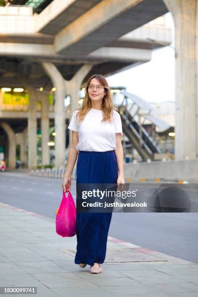 walking thai transgender with pink colored shopping bag - kathoey stock pictures, royalty-free photos & images