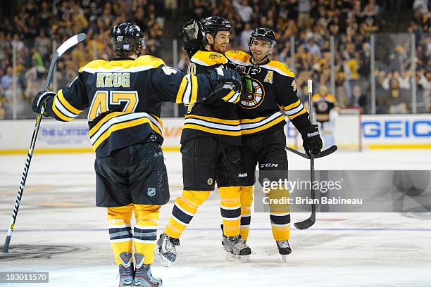 Patrice Bergeron, Adam McQuaid and Torey Krug of the Boston Bruins celebrate a goal against the Tampa Bay Lightning at the TD Garden on October 3,...