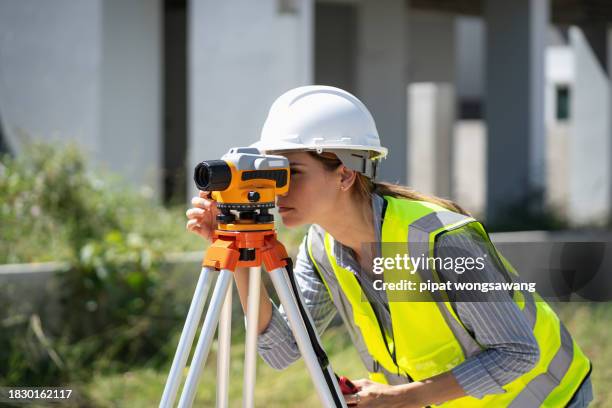 engineer is using a survey camera to measure levels on a construction site. - land surveyor stock pictures, royalty-free photos & images