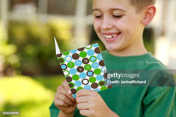 happy smiling young boy reading a thank you card outdoors - thank you card stock pictures, royalty-free photos & images