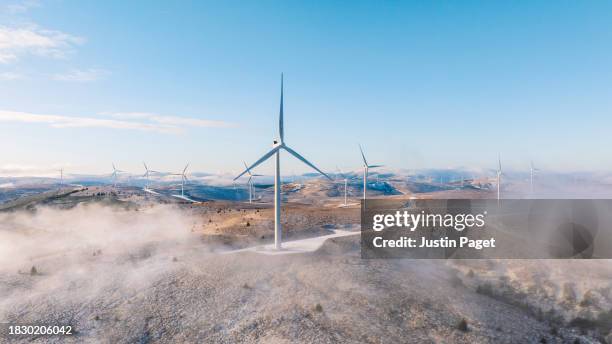 a  drone/aerial view of a wind farm on a hilltop in scotland on a frosty winter's morning - wind power stock pictures, royalty-free photos & images