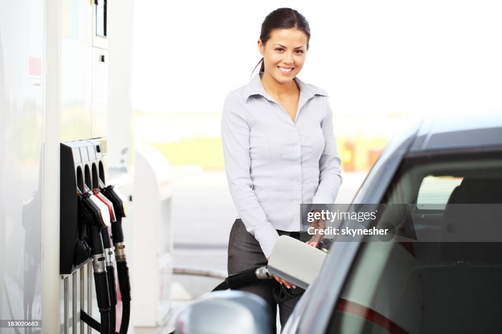 Schöne Mädchen gegossen Treibstoff in der tank des Autos zu Absatz.