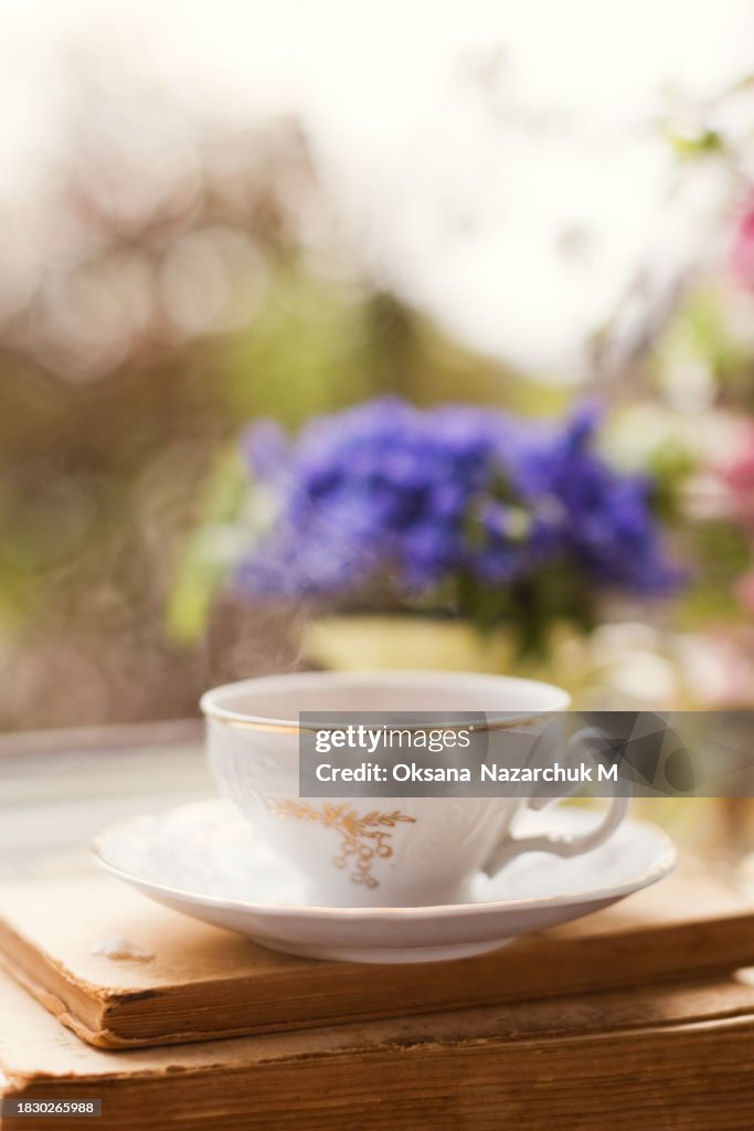 Vintage cup tea near spring flowers