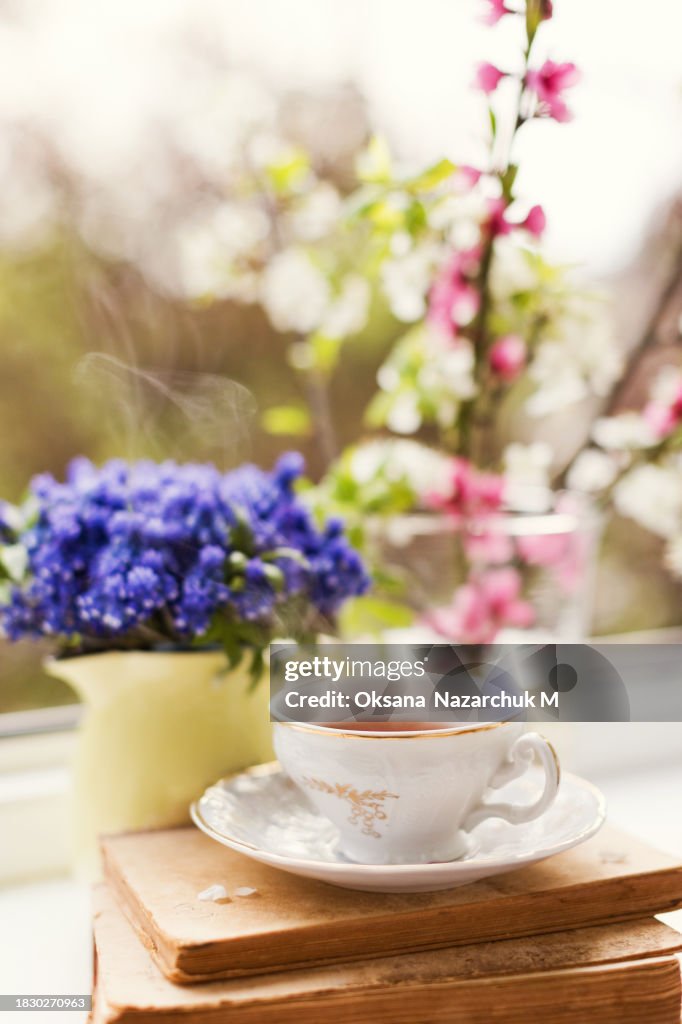Vintage cup tea near spring flowers