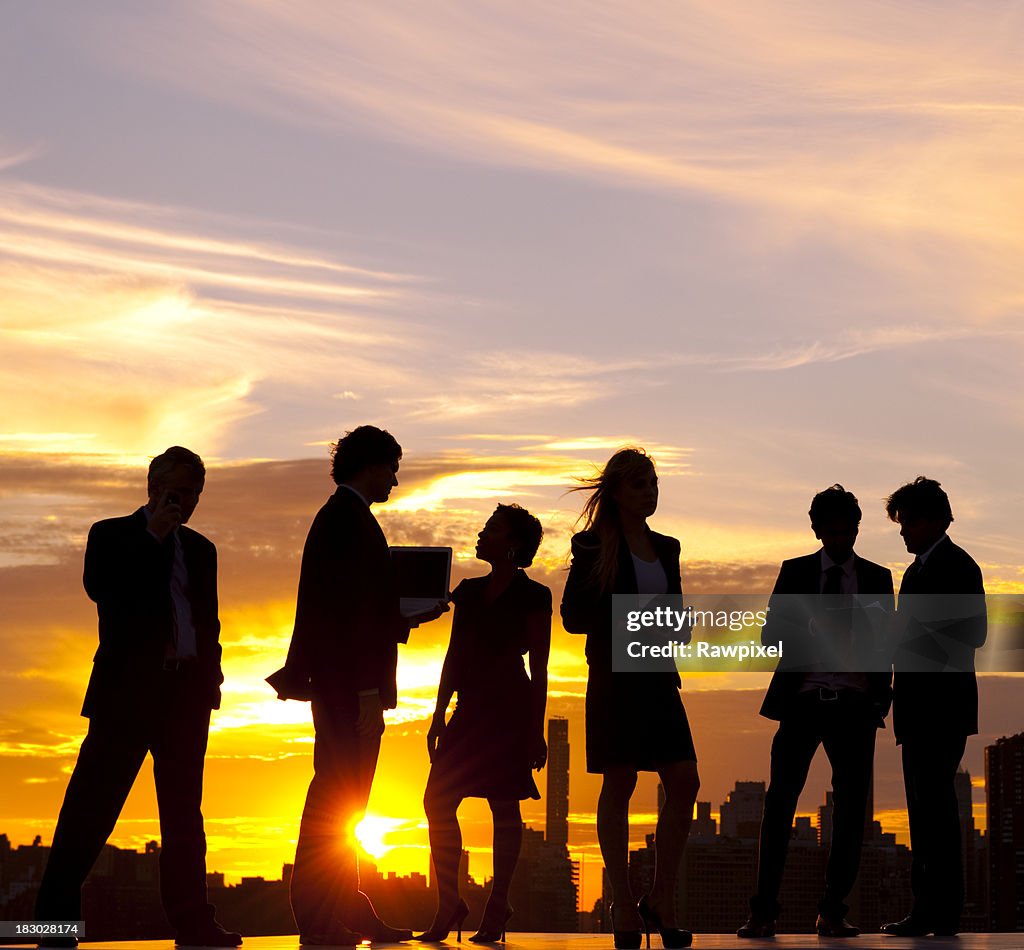 Gens d'affaires de la ville au coucher du soleil