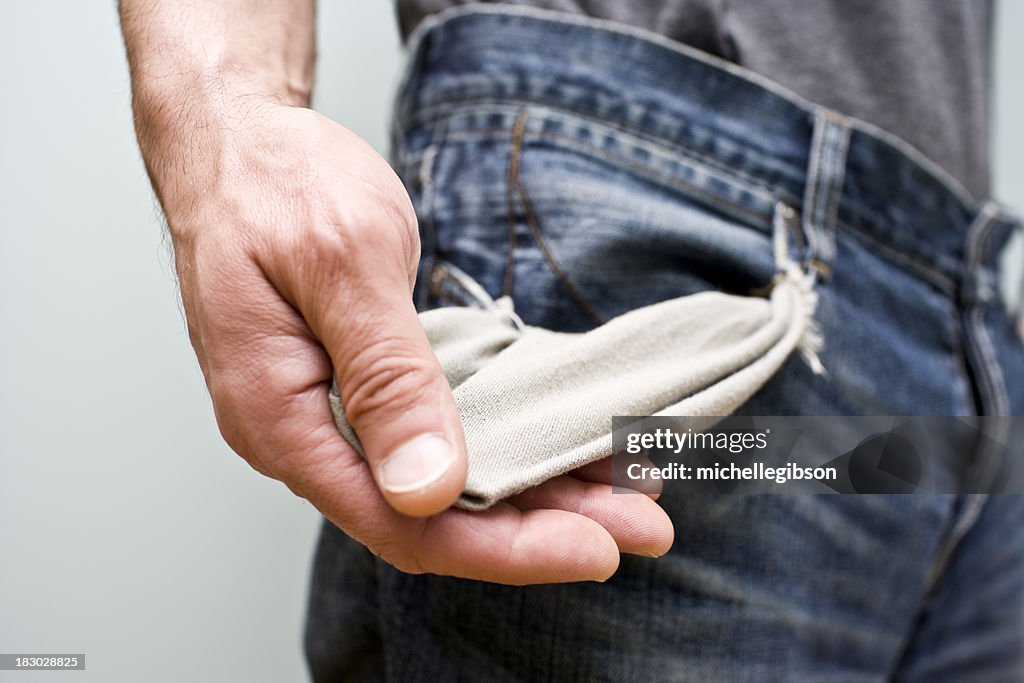 Homem mostra que tem os bolsos vazios