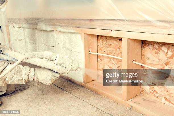 construction worker spraying expandable foam insulation between wall studs - spray stock pictures, royalty-free photos & images