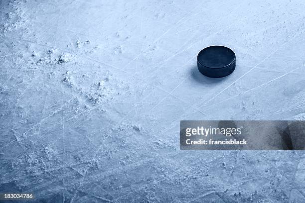 hockey puck on ice - ice hockey stockfoto's en -beelden