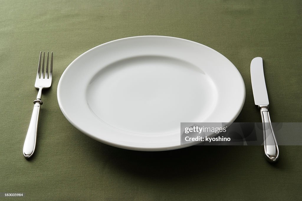 Close-up of place setting on green tablecloth