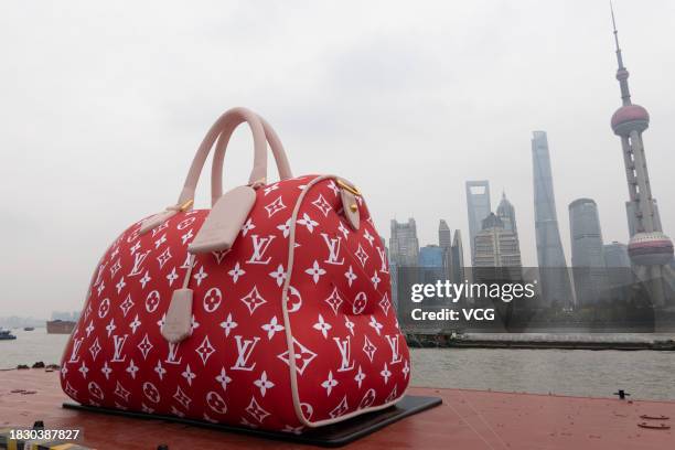 People look at a giant Louis Vuitton bag exhibited at the Bund on December 4, 2023 in Shanghai, China.