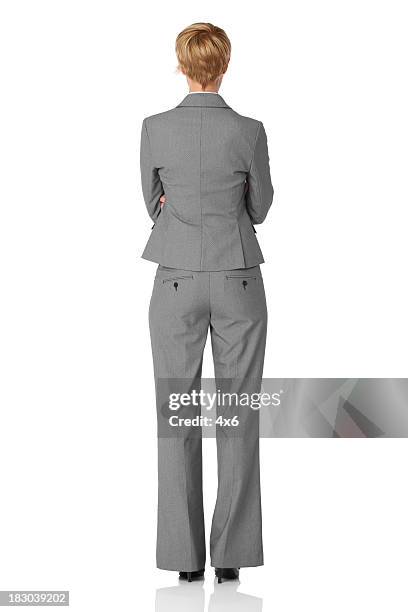 vista posteriore della donna d'affari in piedi con le braccia incrociate - grey suit foto e immagini stock