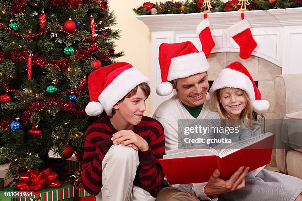 father reading a christmas story - gchutka stock pictures, royalty-free photos & images