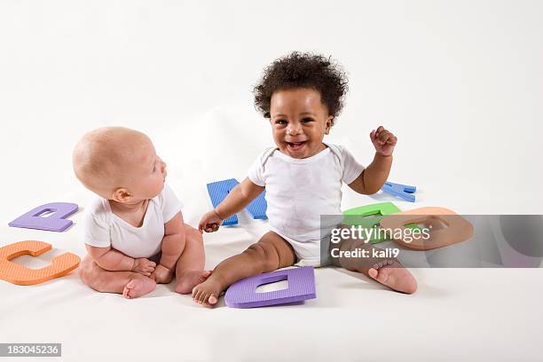 multiracial babies learning abc's, playing with letters - baby girls stock pictures, royalty-free photos & images