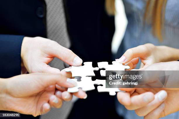 nahaufnahme der hände, die puzzleteile - big idea stock-fotos und bilder