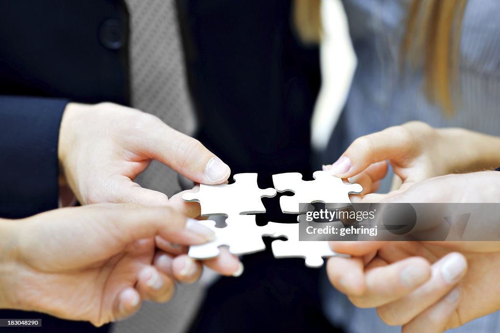 Close up of hands holding puzzle pieces