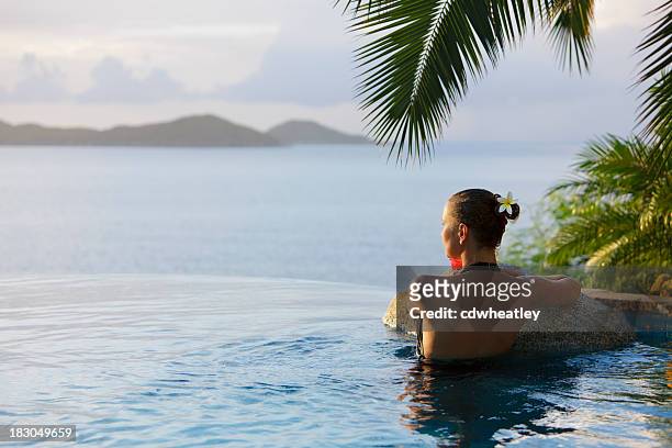 femme dans la piscine à débordement et un jacuzzi sur le spa du centre de villégiature - piscine à débordement photos et images de collection