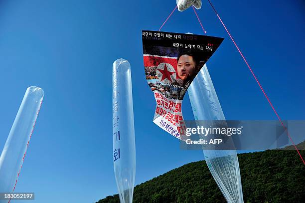 Portrait of North Korean leader Kim Jong-Un hangs from a helium balloon with leaflets during an anti-North Korea rally denouncing the North Korea's...