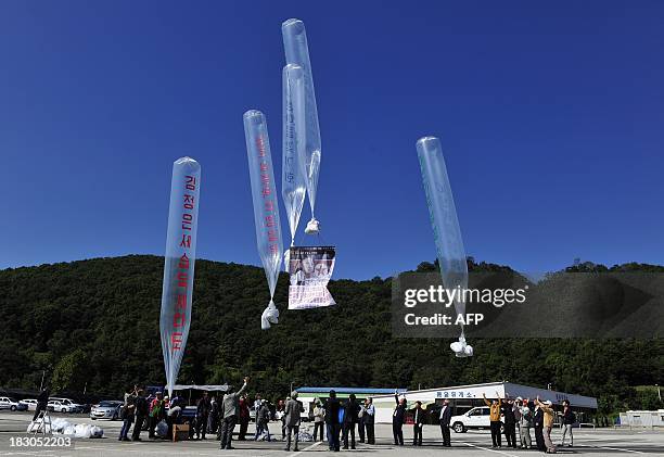 North Korean defectors prepare to release helium balloons carrying leaflets during an anti-North Korea rally denouncing the North Korea's decision to...