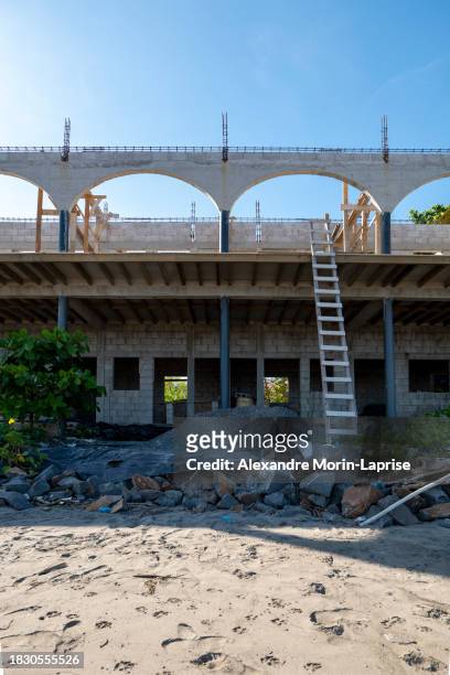 house under construction on the beach with various materials, ladders, and junk - salvadorianische kultur stock-fotos und bilder
