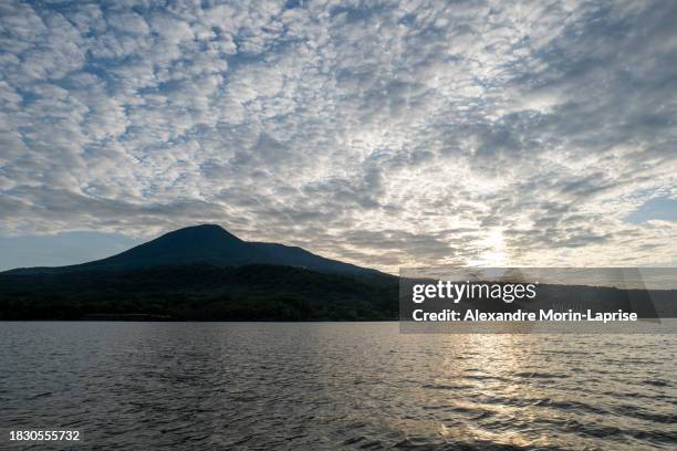 dark coastline seen from afar with volcanic mountain ranges with lush vegetation forests and beaches in front of a calm ocean near la union, el salvador - salvadorianische kultur stock-fotos und bilder