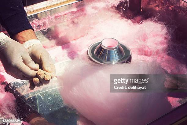 a person in latex gloves making pink cotton candy on a stick - cotton candy stock pictures, royalty-free photos & images