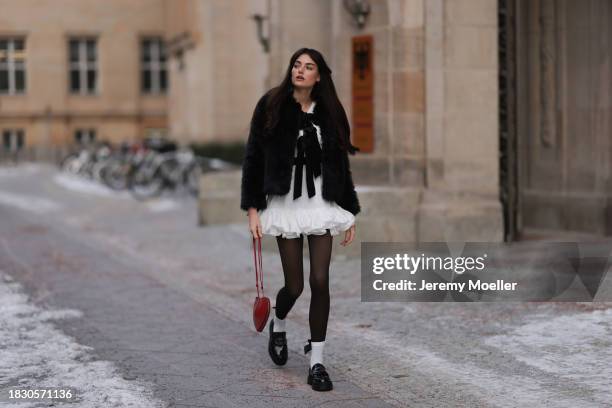 Celine Bethmann seen wearing Mango white ruffled short dress, Pepe Jeans black fake fur jacket with ribbon details, Calzedonia black tights, Alaia...