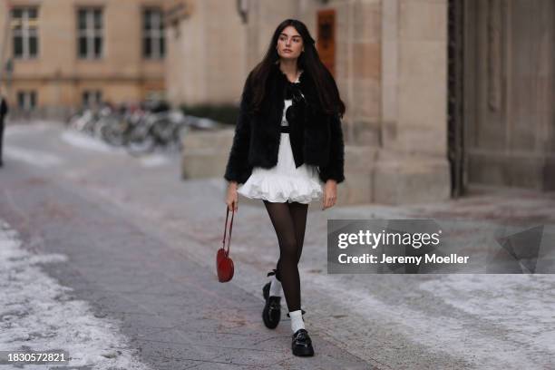 Celine Bethmann seen wearing Mango white ruffled short dress, Pepe Jeans black fake fur jacket with ribbon details, Calzedonia black tights, Alaia...