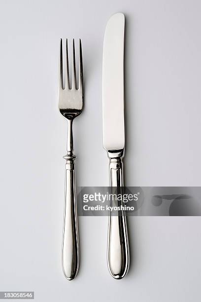 isolated shot of knife and fork on white background - tafelmes stockfoto's en -beelden