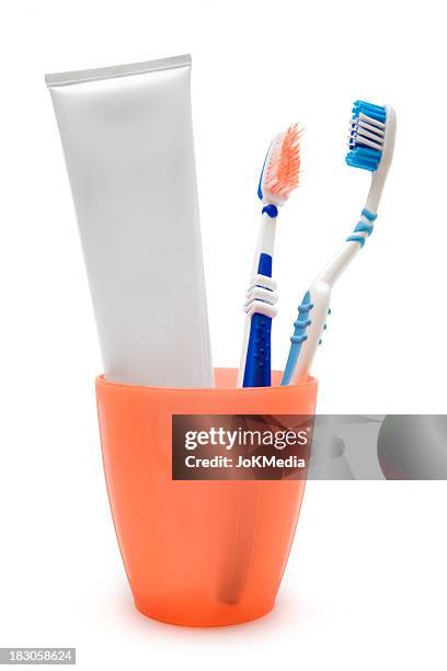 toothpaste and tootbrushes in a cup - toothbrush stock pictures, royalty-free photos & images