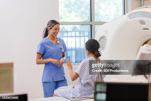 female cat technician smiles as unrecognizable female patient speaks - ct röntgen bildbanksfoton och bilder