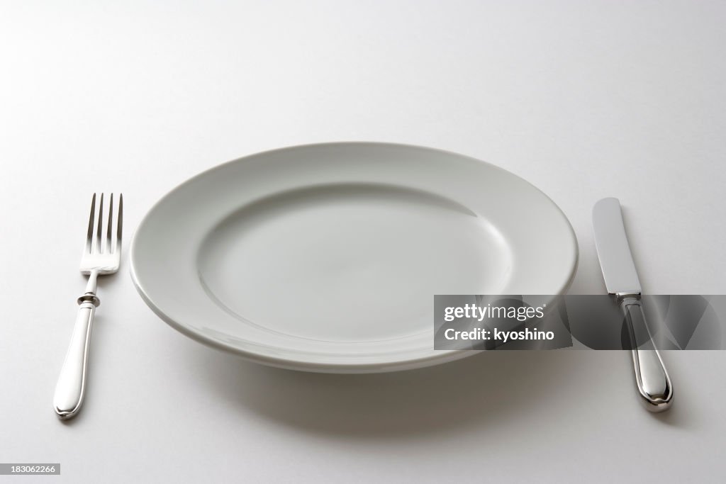 Isolated shot of empty plate and cutlery on white background