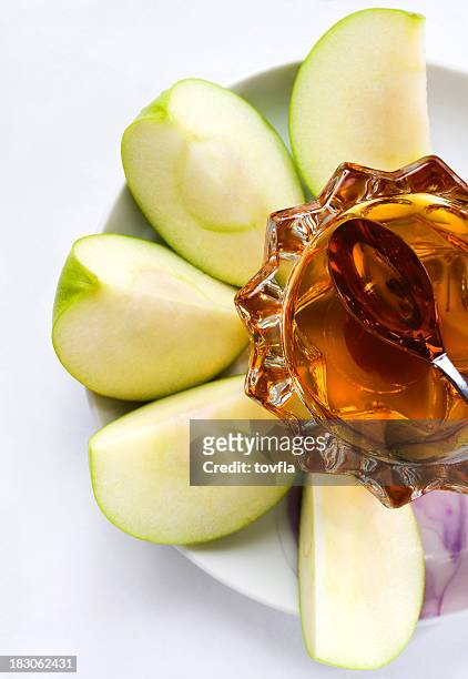 a plate with sliced apples and honey on it  - green apple slices stock pictures, royalty-free photos & images