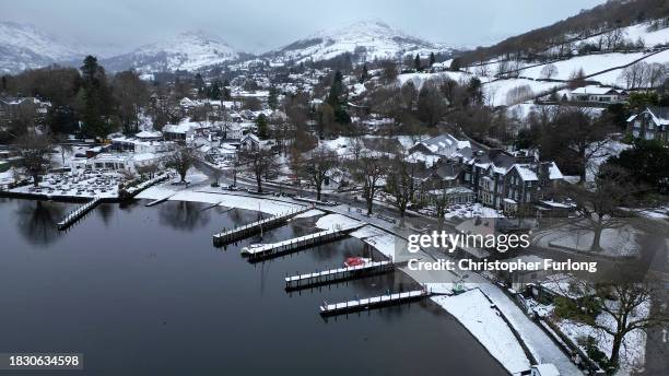 Recent snow, freezing temperatures and a heavy sky create a monochromatic scene over Lake Windermere and its sailing jettys atb Ambleside, Cumbria on...