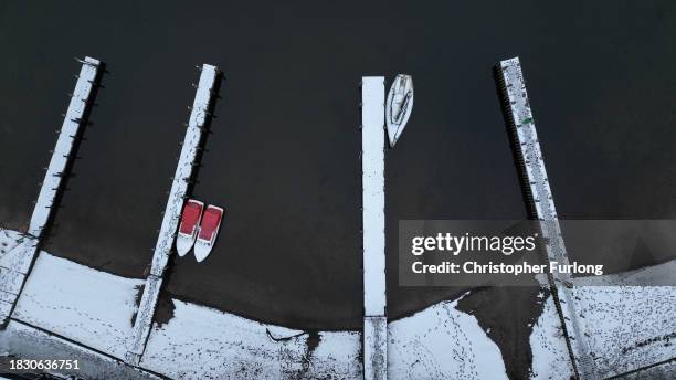 Recent snow, freezing temperatures and a heavy sky create a monochromatic scene over Lake Windermere and its sailing jettys atb Ambleside, Cumbria on...