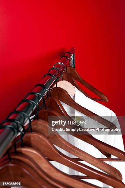 elegant clothing organizer hung on red wall. - white coat fashion item stock pictures, royalty-free photos & images