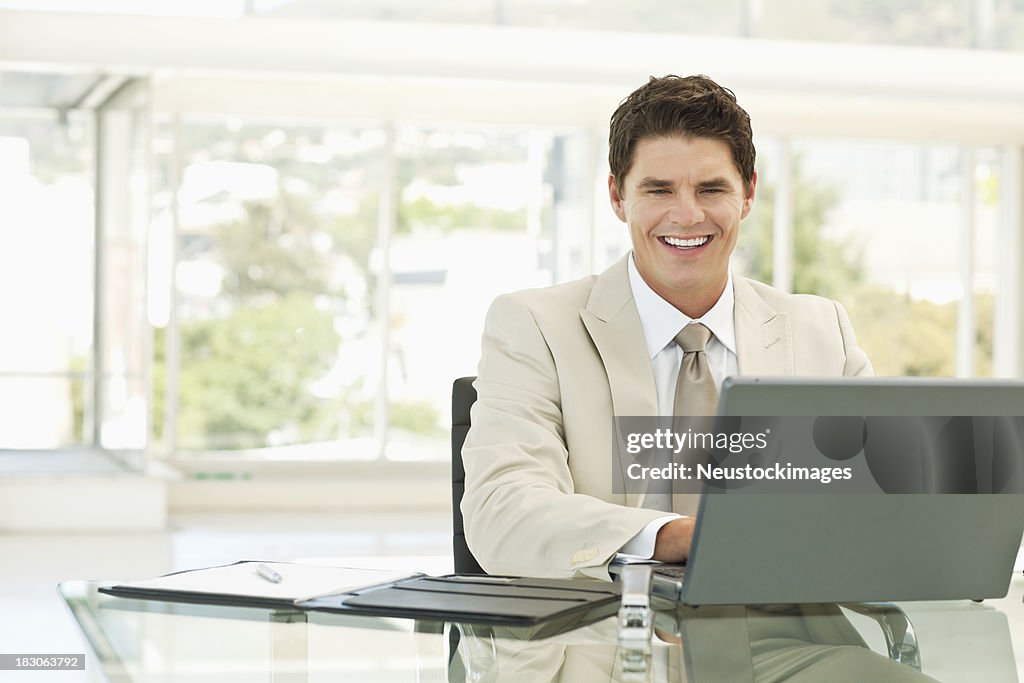 Homem de Negócios atraente usando um Laptop no escritório