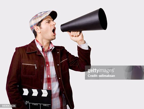 film director shouting with megaphone while holding film slate - film director stock pictures, royalty-free photos & images